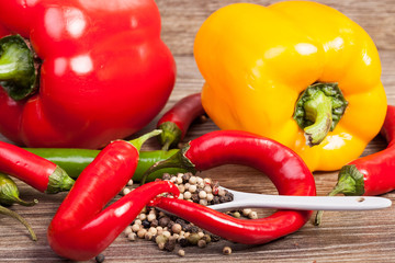 Spicy and sweet pepper on wooden background in studio photo. Healthy eating