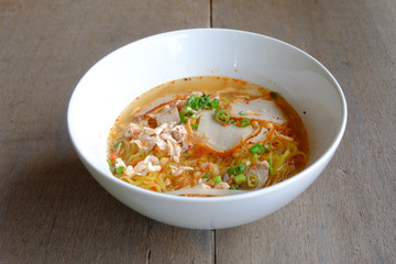 spicy pork noodles on wood floor