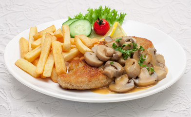 Champignonschnitzel mit Pommes  auf weißem Stoffuntergrund