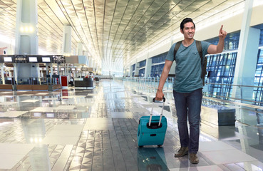 Portrait of asian traveler with luggage pointing something