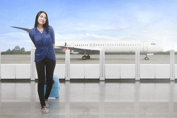 Portrait of asian traveler carrying suitcase waiting plane