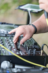 Dj works on mix console at outdoor party