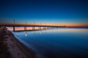 Amazing sunrise on the pier at the seaside. Gdynia Orlowo, Poland
