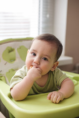 Thoughtful little baby boy eating