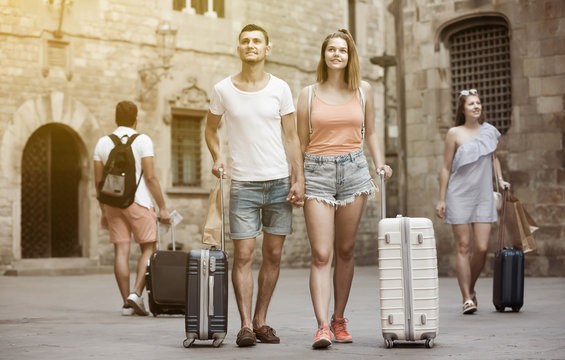 Active man and woman in shorts with luggage