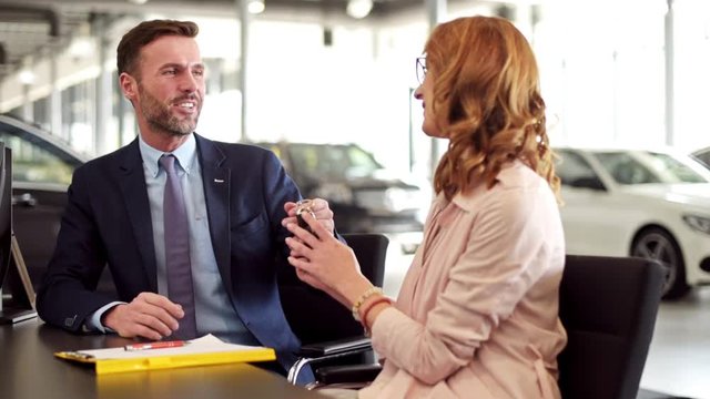 Salesman giving customer a contract and keys