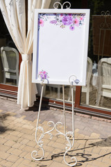 Fototapeta na wymiar Wedding board on the white forged stand with a guest list