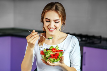 A young girl eats a delicious vegetable salad. The concept is healthy food, diet, vegetarianism, weight loss.