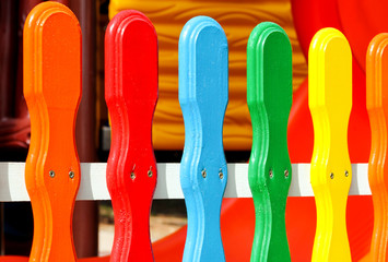 Fototapeta premium Colorful wooden decorative fence in the park. Colored wooden plank panel background texture. Art wooden background. Creative colorful wallpaper.