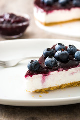 Piece of blueberry cheesecake on wooden table
