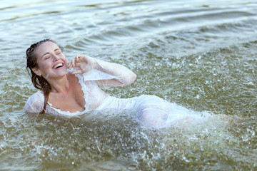 Woman swims in the water during a shower, she rejoices and rejoices.