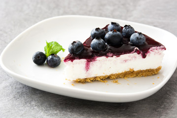 Piece of blueberry cheesecake on wooden table
