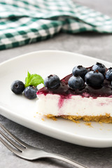 Piece of blueberry cheesecake on wooden table
