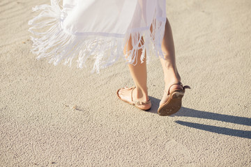 Female legs in sandals go on a desert sand - obrazy, fototapety, plakaty