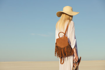 Trip alone. Woman walking away on a sand in desert.