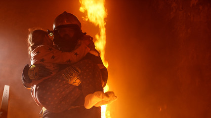 Obraz premium Brave Fireman Holds Saved Girl in His Arms in a Burning Building with open fire in the Background.