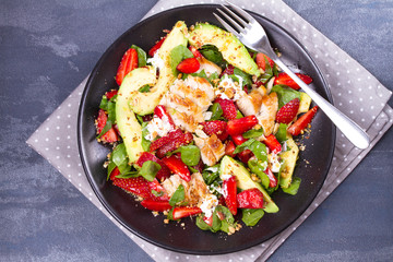 Strawberry, avocado, spinach salad with chicken. View from above, top studio shot