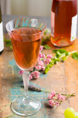 Cold summer rose wine, served in beautiful glass on terrace in cafe with romantic flowers