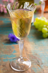 Cold summer white wine, served in beautiful glass on terrace in cafe with romantic flowers