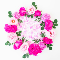 Round floral frame of pink roses and pink petals on white background. Flat lay, top view. Floral pattern
