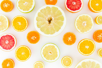 Obraz premium Citrus fruits background made of lemon, orange, grapefruit, sweetie and pomelo on white background. Flat lay, top view.