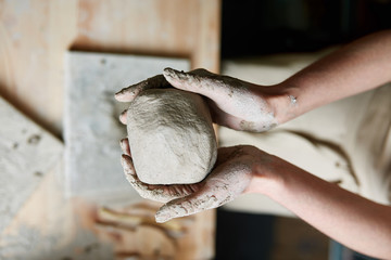 The artist sculpts a ball of clay