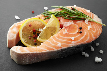 raw salmon steak, appetite fish with seasoning on a dark background
