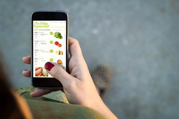Woman walking smartphone online supermarket interface