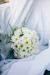 Wedding bouquet from fresh spring flowers. Bridal bouquet with white dahlia flowers on white cloth