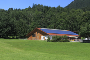 Große Fläche mit Photovoltaikmodulen auf dem Dach eines landwirtschaftlichen Gebäudes am...
