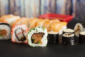 Japanese sushi on black and wooden background
