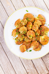 Smashed Potatoes with parsley, dried rosemary, lemon zest and yogurt sauce. View from above, top studio shot