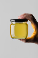 Honey Jar Mock-Up - Male hands holding a honey jar on a gray background