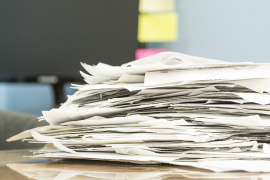 stack of documents on desktop in office.