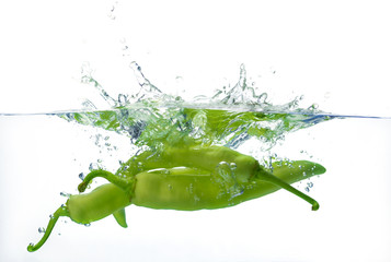 pepper dropped into water with splash isolated on white