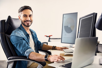 Happy male having job on notebook computer