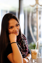 Beautiful girl drinking ice mocha shake in a cafe