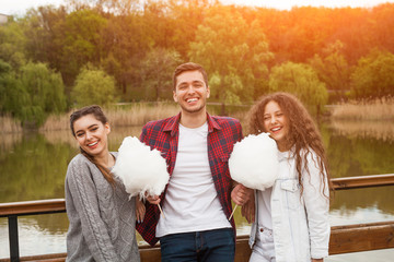 Man with candy floss and girls smiling