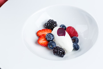 Vanilla ice cream scoops with fresh berries