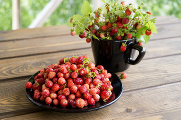 Strawberries in a white mug on a rustic wooden table. The concept of organic food. rustic style
