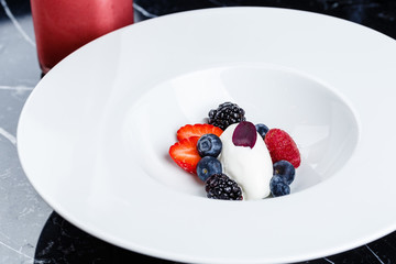 Vanilla ice cream scoops with fresh berries