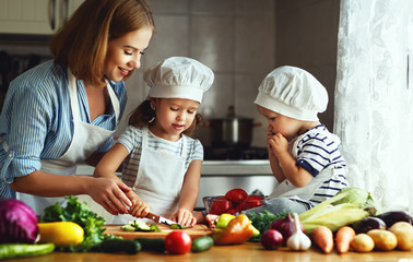 Healthy eating. Happy family mother and children prepares  vegetable salad