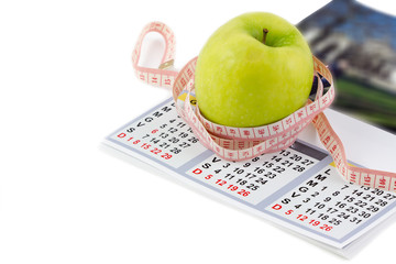 Green apples with measured the meter and calendar concept diet health.