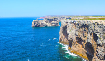 Fototapeta na wymiar View of famous Cliffs of Moher and wild Atlantic Ocean, Portuguese coastline close to Cape St. Vincent in Portugal on a sunny and clear day with the beautiful blue Atlantic in the background.