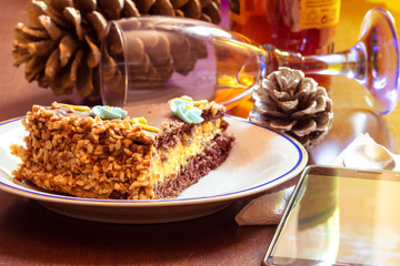 Blurred Vintage style. Chocolate cake with cream and smartphone and glass on table background.