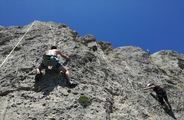Fototapeta na wymiar Pareja escalando pared de montaña