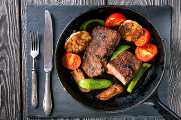 Frying pan with steak and vegetables