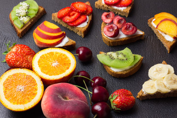 Sweet fruit bruschetta on black concrete background.  Selective focus.