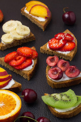 Fresh fruit sanwiches on slate black background.  Selective focus.