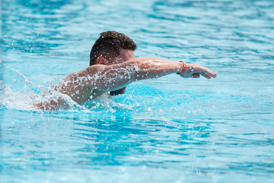 Man athlete swimmer in swimming pool with blue fresh water